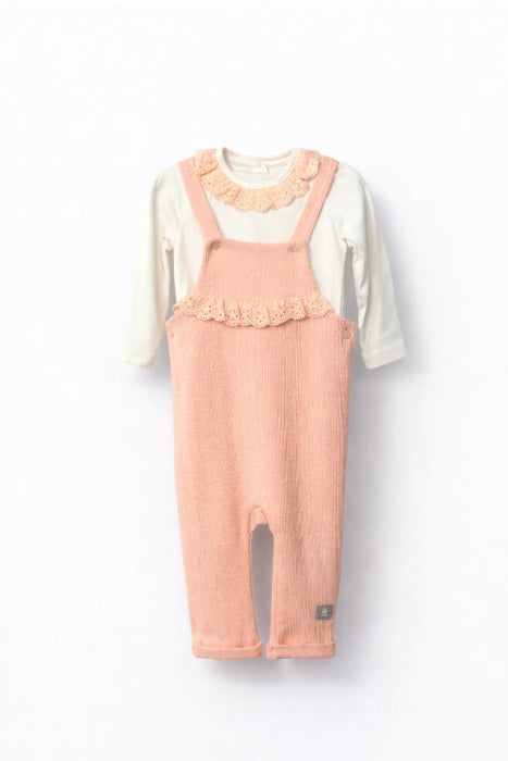 Children's outfit with pink overalls and white shirt on a white background