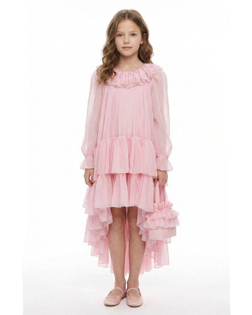 Young girl wearing a pink dress with ruffles on a white background