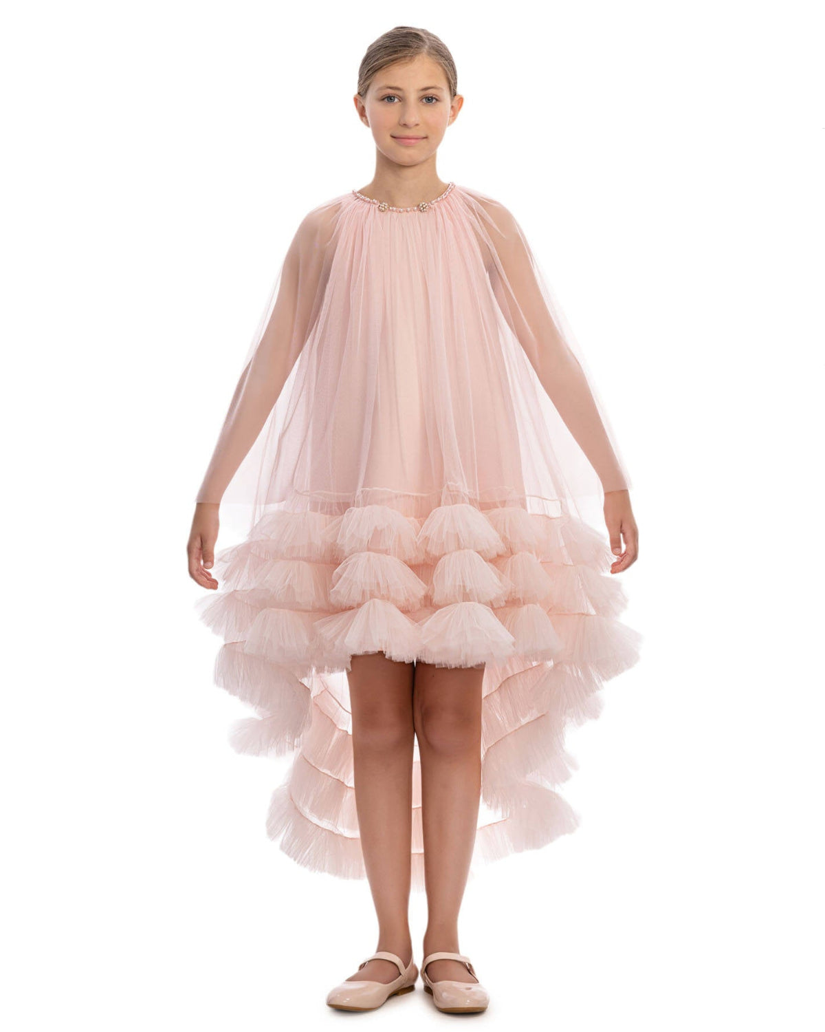 Young girl wearing a pink ruffled dress on a white background