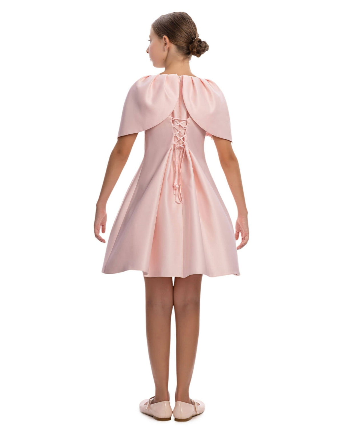 Pink dress with capelet worn by a model on a white background