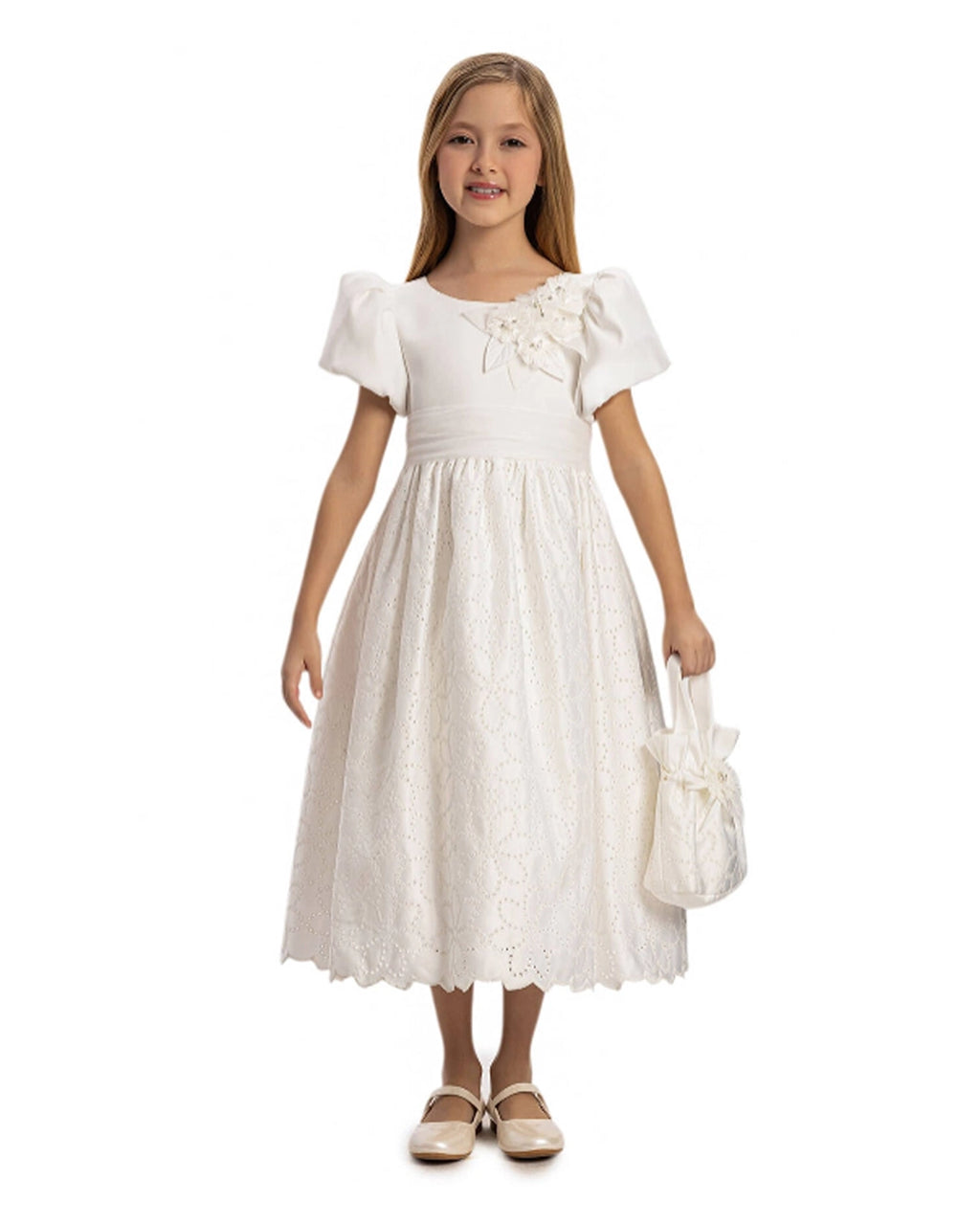 Young girl wearing a white dress holding a matching bag on a white background